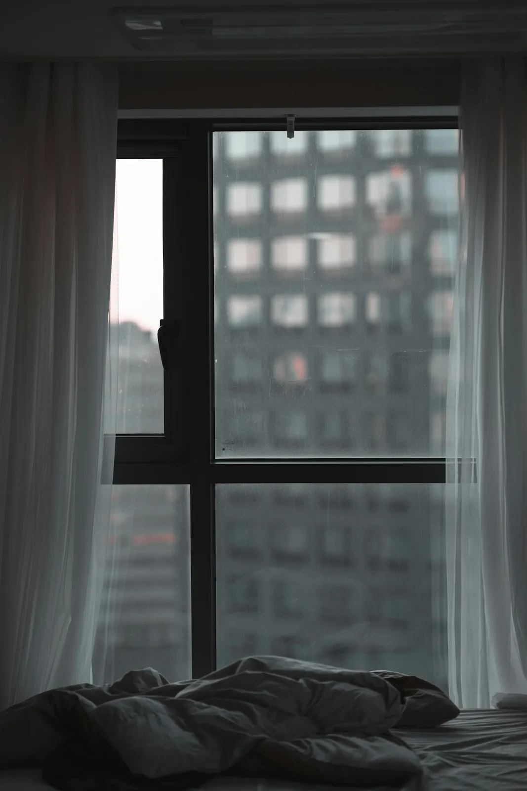Sheer curtains hanging beside an open window in a real interior photograph.